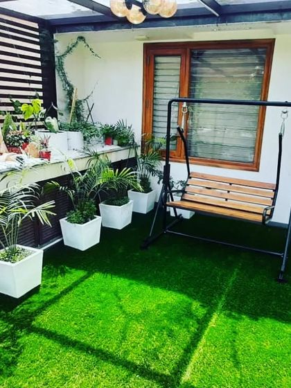 A comfortable swing is a perfect addition to this green balcony, creating a spot for relaxation with a view.