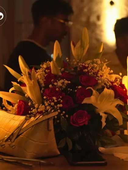 A simple yet elegant table setting for our own anniversary celebration. A bouquet of red roses and lilies, surrounded by glowing candles, creates a classic and romantic ambiance.