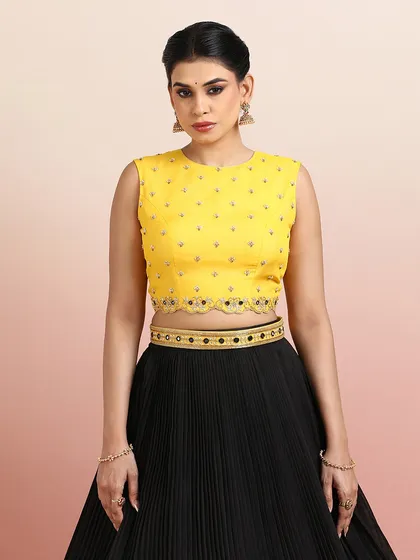 Another close-up of the yellow blouse with the black lehenga, focusing on the elegant neckline and embellishments.