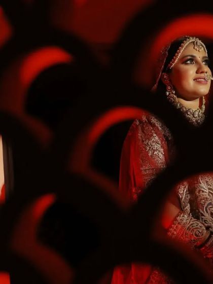 A creative portrait of the bride, framed by the intricate patterns of a jali screen. We use unique angles and lighting to create artistic and memorable images.