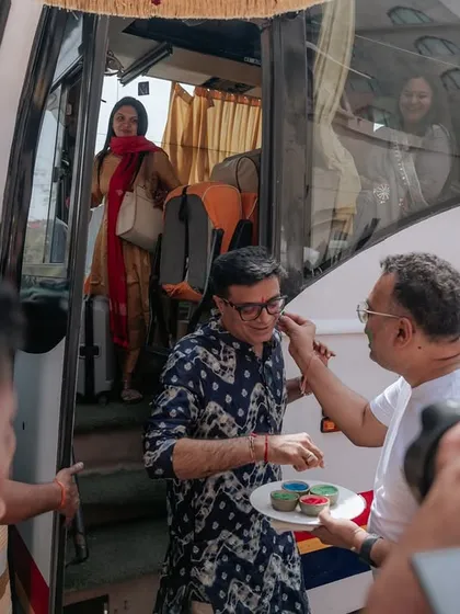 A guest arriving by bus is greeted with a traditional and colorful welcome. We manage logistics and hospitality for destination weddings seamlessly.