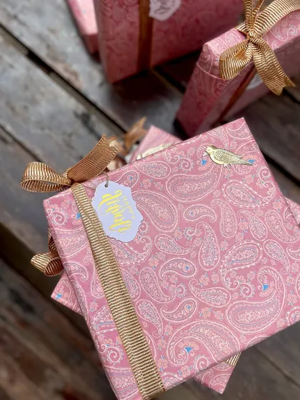 A beautifully wrapped gift box from the "Jashn" festive series. The plush paisley print, gold ribbon, and custom "Happy Diwali" tag create a gift that feels both traditional and luxurious.
