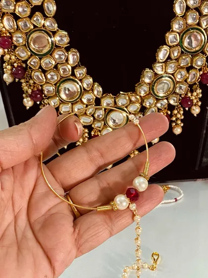 A simpler bridal nath with a single red bead and pearl. This elegant design is also available for rent.