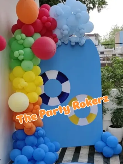 Another part of the pool party decor, this backdrop features lifebuoy rings and a splash of blue balloons at the bottom.
