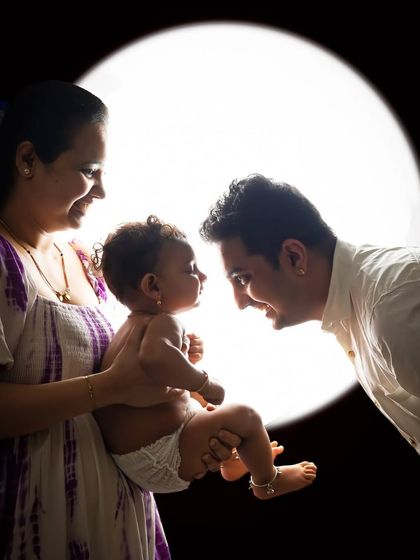 A backlit family portrait against a circular light source. This creative setup produces stunning, high-contrast images that feel both modern and timeless.