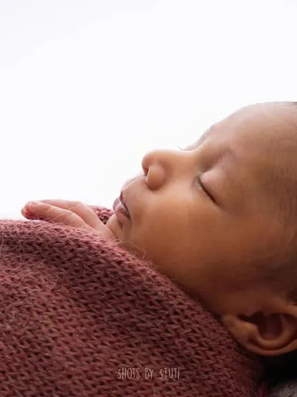 A close-up of a newborn in a beautiful floral headband. I source my headbands from trusted vendors who use soft, baby-safe materials.
