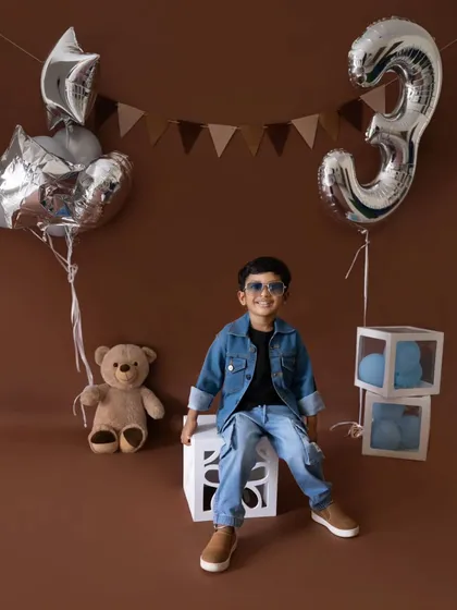 A classic portrait from the third birthday session, showing the full setup with silver balloons and a teddy bear.