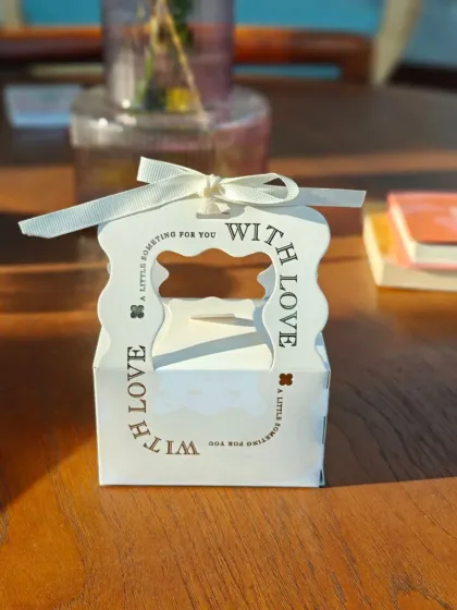 A closer look at the "With Love" Valentine's Day hamper box. Inside, you'll find a Citrus Bloom moisturizer, Mint Shizzle lip balm, and a Good Intentions soy wax candle, a perfect trio for a special someone.