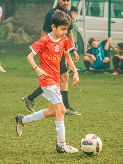 A player dribbles with determination, showcasing the skills learned in our youth football training program.