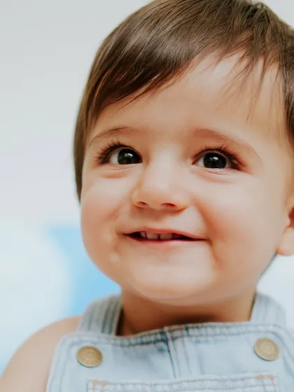 The sweetest smile. This close-up from a minimalist session with blue tones shows how I capture pure, simple joy.