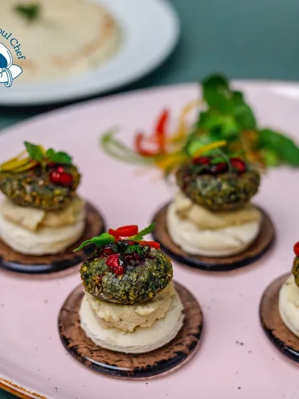 A Middle Eastern delight, miniaturized for your event. These mini falafel bites are served on a bed of hummus over a small pita circle, offering all the classic flavors in one perfect mouthful.
