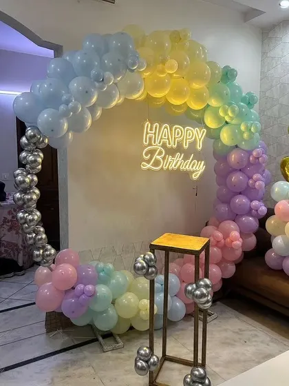 A beautiful pastel rainbow balloon ring with a "Happy Birthday" neon sign. This setup is perfect for adding a soft and cheerful touch to any birthday party.
