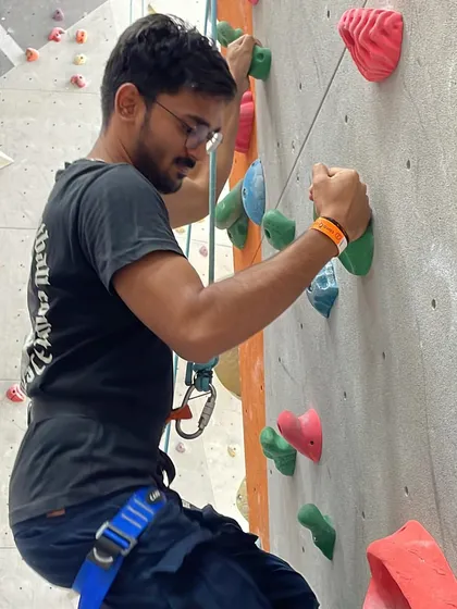 A team member focuses on his ascent during a corporate outing. The individual challenge contributes to a collective sense of achievement.