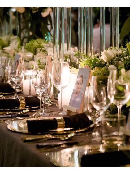 Another angle of the sophisticated black, gold, and white table setting. The reflection on the table adds a layer of depth and luxury, highlighting the high quality materials used in the setup.