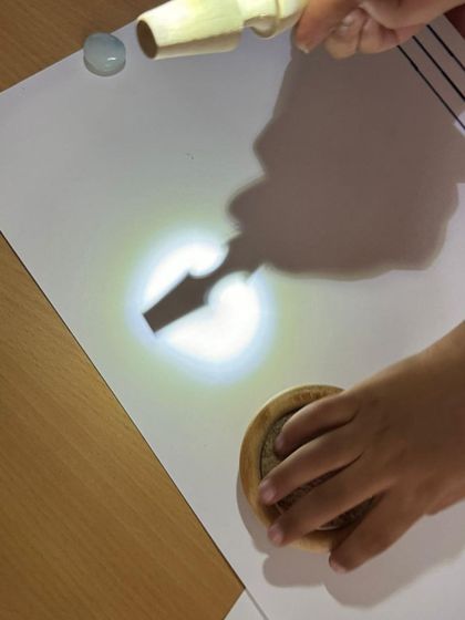 In our emergent literacy workshop, children explore light and shadow. By tracing the shadows of objects, they develop fine motor control and visual thinking, turning a science concept into a pre-writing and storytelling activity.