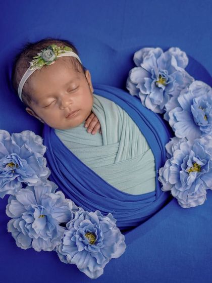 Wrapped in a heart of blue. This setup uses a heart-shaped prop to frame the beautifully swaddled baby, creating a lovely, symbolic image.