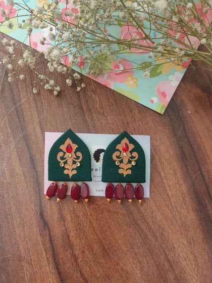 These hand-painted earrings are shaped like traditional arches and feature intricate designs with bead drops. They are available in both green and red, perfect for festive or wedding attire.