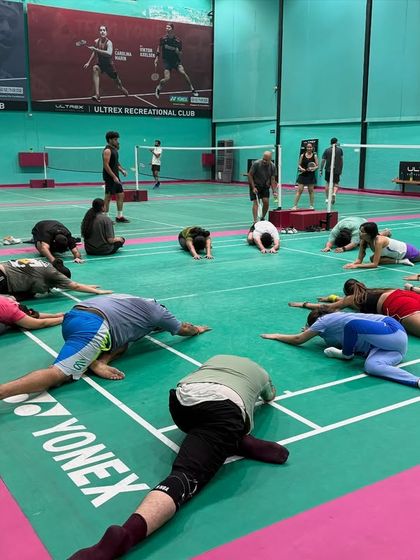 Another angle of our group cool-down session. We guide players through essential stretches to improve flexibility and prevent common badminton injuries.