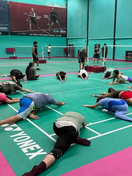 Another angle of our group cool-down session. We guide players through essential stretches to improve flexibility and prevent common badminton injuries.