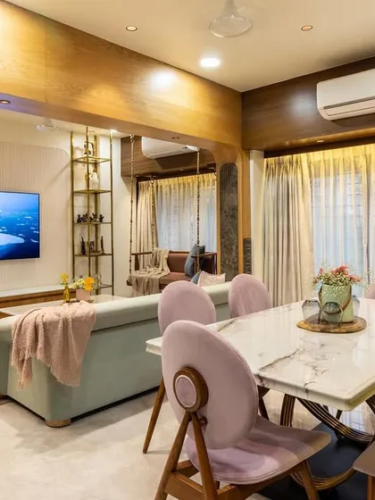 An open-plan view showing the connection between the dining and living areas, unified by a warm wood and pastel color scheme.