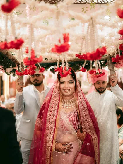 The bride's grand entrance under a beautiful 'phoolon ki chadar', a truly magical moment.