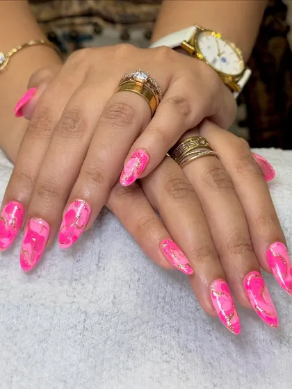 Obsessed with this vibrant pink marble nail art. This look combines shades of bright pink with delicate gold foil accents to create a stunning, stone-like effect on long stiletto nail extensions. Each nail is a unique piece of art.