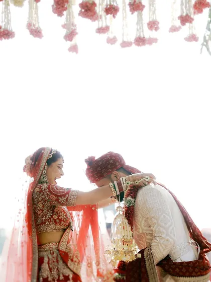 A beautifully composed shot of the Varmala ceremony, with the bride garlanding the groom under a canopy of flowers.