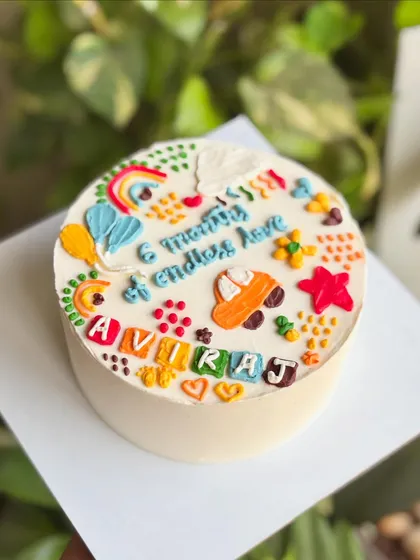 Six months of giggles and scribbles, doodled in frosting! This colorful doodle cake celebrates a baby milestone with fun, hand-piped illustrations.