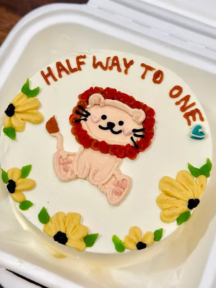 A super cute bento cake for a six-month milestone, featuring a hand-drawn lion cub surrounded by sunflowers. We love celebrating these little moments.