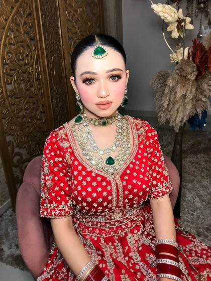 A beautiful portrait of the bride, with her emerald jewelry sparkling against the red of her outfit.