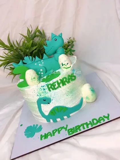 A fun dinosaur-themed cake for a birthday celebration. This whipped cream cake is decorated with green splatter, edible dino cutouts, and a large fondant dinosaur on top.