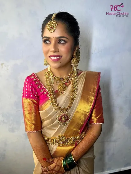 Our gorgeous bride Kavya on her muhurtham day. She chose a magnificent layered temple jewellery set with a statement choker and a long haram featuring a large, intricate pendant.