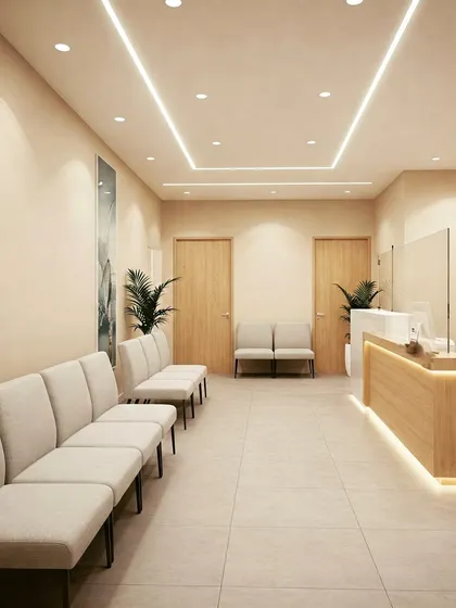 A minimalist and clean clinic waiting room with a neutral color palette. The design features a simple wood and white reception desk, bench seating, and linear ceiling lights for a calm and orderly feel.