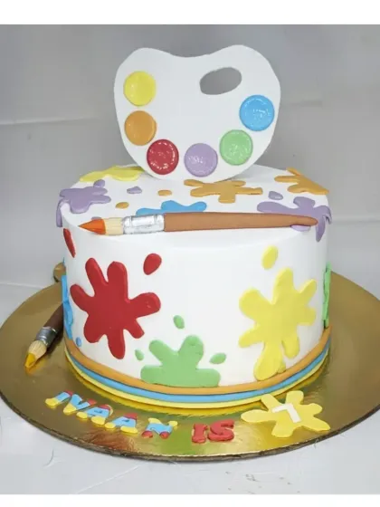 A colorful cake for a painting lover. This chocolate truffle cake is decorated with paint splatters, a palette, and brushes, all made from fondant.