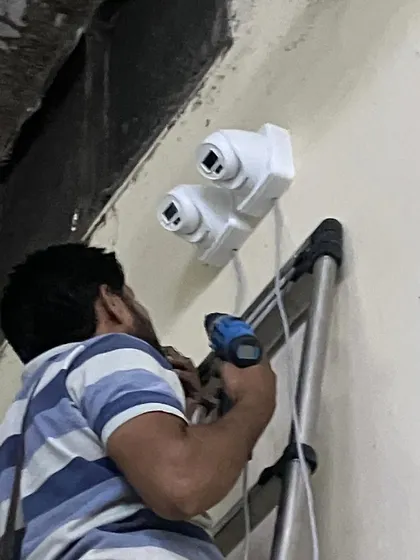 Securing the dual-camera setup to the wall. This will provide a wide field of view for monitoring a large production area.