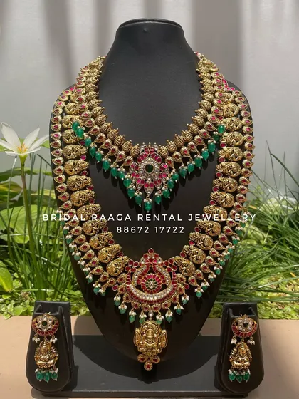 This beautiful set combines mango motifs with floral designs, studded with red and green Kemp stones. The choker has a unique V-shape design with a central emerald.