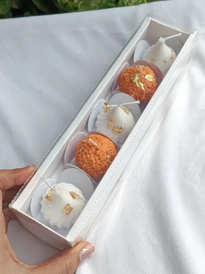 The laddoo and modak gift set, shown from an angle to highlight the 3D quality of the candles.