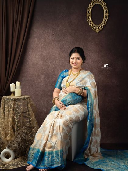 A classic seated portrait of a mom-to-be in a saree. Her gentle smile and the way she cradles her bump radiate peace and happiness.