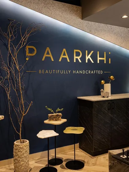A close-up of the feature wall at Paarkhi, where the brand's identity is elegantly displayed in golden lettering against a deep, signature blue. This detail shows our commitment to integrating brand elements seamlessly into the architectural design for a powerful first impression.