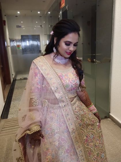This bride is ready for her engagement in a beautiful pastel pink and floral lehenga. The makeup is soft and romantic to match.