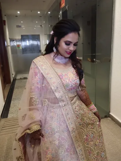 The intricate details of the lehenga are matched with soft pink and rose gold makeup tones.