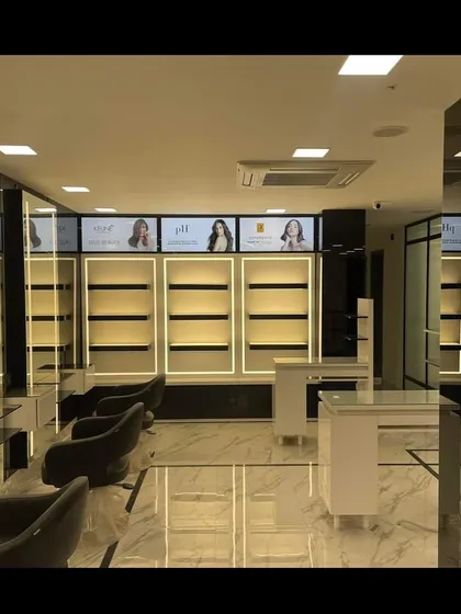 A view of the product display and styling area we designed for a salon. The backlit shelving units are designed to highlight products effectively, turning retail into a key part of the salon's aesthetic and revenue stream.