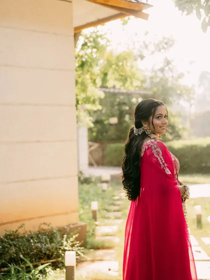 A beautiful shot of the bride in her pink haldi outfit, looking back with a smile.