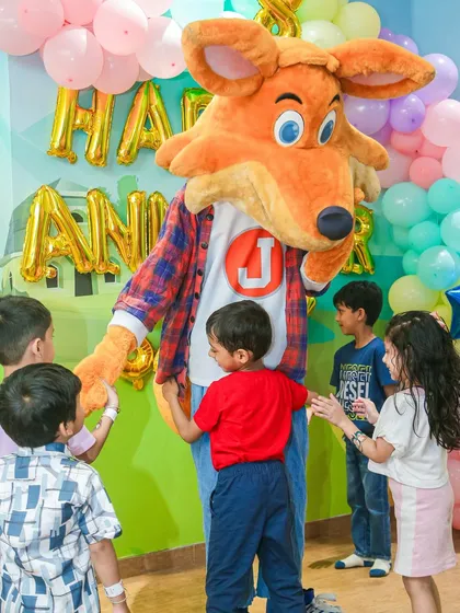 Our mascot, J the Fox, surrounded by excited children during our anniversary celebration. A mascot appearance is guaranteed to bring smiles.