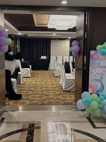 The entrance to the mermaid party, decorated with a welcome sign, balloon arrangements, and character props.