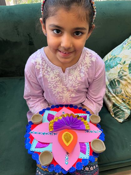 A beautifully crafted paper diya holder made by a student in our Diwali workshop.