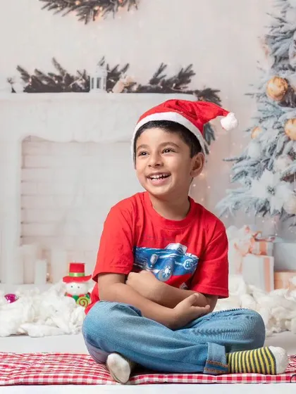 A collection of happy kids enjoying my two distinct Christmas setups: a bright, snowy winter scene and a warm, rustic brick fireplace.
