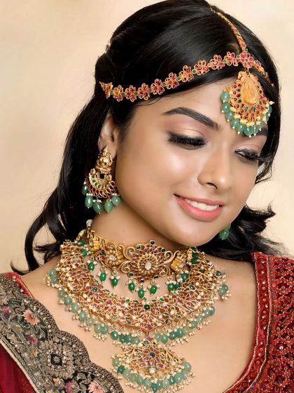 A beautiful reception look featuring our Kundan-style jewellery with green bead drops. The matching matha patti and chandbali earrings complete the ensemble.