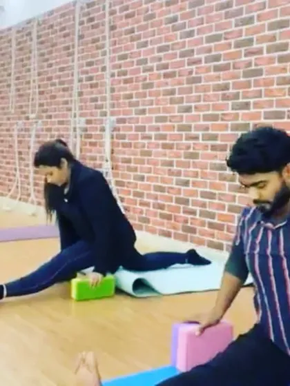 Students working on their Hanumanasana (splits) preparation using blocks for support. This gradual approach helps to open the hips safely.