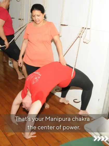 That spot in your solar plexus holds your fear, but it also holds your fire. That is your Manipura chakra, the center of power. Here, a student works on a deep backbend with assistance, a powerful way to stimulate this chakra and transform fear into courage.